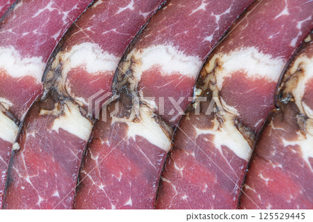 Top view of smoked pork salami chorizo sausages slices background. Raw smoked salami pattern Top view of smoked pork salami chorizo sausages slices background. Raw smoked salami pattern 125529445