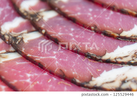 Top view of smoked pork salami chorizo sausages slices background. Raw smoked salami pattern Top view of smoked pork salami chorizo sausages slices background. Raw smoked salami pattern 125529446