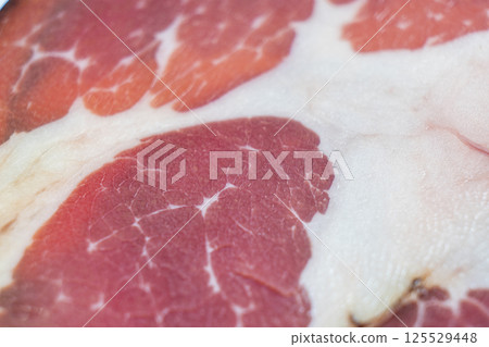 Top view of smoked pork salami chorizo sausages slices background. Raw smoked salami pattern 125529448