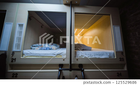 Capsule hotel beds providing comfortable and affordable accommodation 125529686