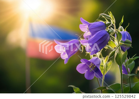 A bunch of purple flowers are in front of a flag 125529842