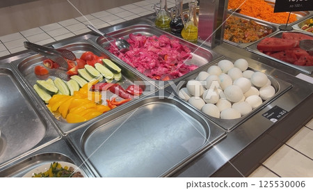 Self-service buffet offering fresh and colorful vegetables, eggs, and watermelon Self-service buffet offering fresh and colorful vegetables, eggs, and watermelon 125530006