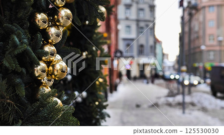 Golden christmas balls decorating a christmas tree on a blurred city street Golden christmas balls decorating a christmas tree on a blurred city street 125530030