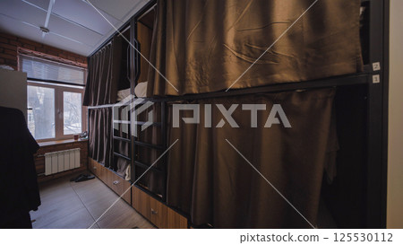 Hostel room with brown curtains providing privacy in capsule beds Hostel room with brown curtains providing privacy in capsule beds 125530112