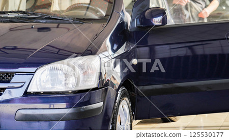 Car wash worker cleaning vehicle with high pressure water jet Car wash worker cleaning vehicle with high pressure water jet 125530177