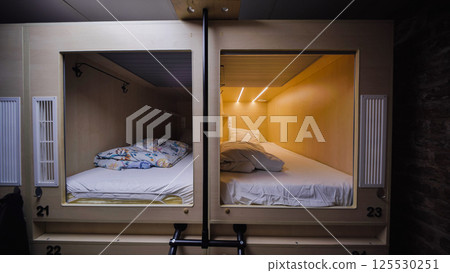 Capsule hotel beds providing comfortable and private sleeping spaces 125530251