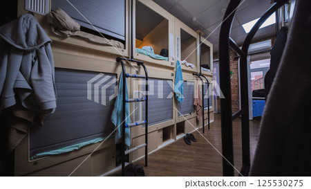 Capsule hotel offering comfortable and private sleeping pods with rolling shutters for guests 125530275