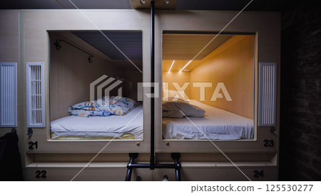 Empty capsule hotel room inviting guests for comfortable rest 125530277