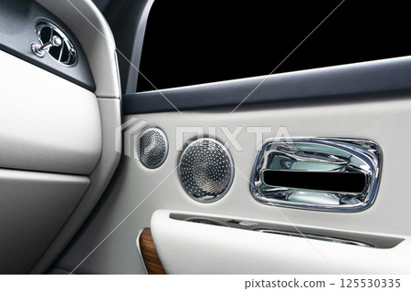 Door handle with power window control buttons of a luxury passenger car. White perforated leather interior with stitching and natural wood panel. Modern car interior details. Car detailing. Car inside Door handle with power window control buttons of a luxury passenger car. White perforated leather interior with stitching and natural wood panel. Modern car interior details. Car detailing. Car inside 125530335