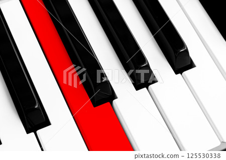 Top view of piano keys with one red button. Close-up of piano keys. Close frontal view. Piano keyboard with selective focus. Diagonal view. Piano keyboard perspective. 125530338