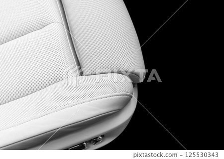 White leather interior of the luxury modern car. Perforated white leather comfortable seats with stitching isolated on black background. Modern car interior details. Car detailing. Car inside White leather interior of the luxury modern car. Perforated white leather comfortable seats with stitching isolated on black background. Modern car interior details. Car detailing. Car inside 125530343