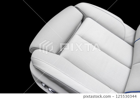 White leather interior of the luxury modern car. Perforated white leather comfortable seats with stitching isolated on black background. Modern car interior details. Car detailing. Car inside White leather interior of the luxury modern car. Perforated white leather comfortable seats with stitching isolated on black background. Modern car interior details. Car detailing. Car inside 125530344