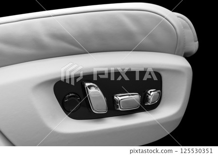 White leather interior of the luxury modern car. Perforated white leather comfortable seats with stitching isolated on black background. Modern car interior details. Car detailing. Car inside White leather interior of the luxury modern car. Perforated white leather comfortable seats with stitching isolated on black background. Modern car interior details. Car detailing. Car inside 125530351