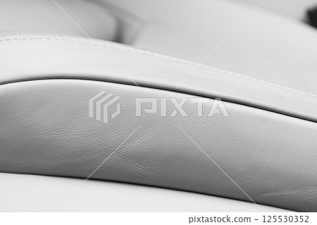 White leather interior of the luxury modern car. Perforated white leather comfortable seats with stitching. Modern car interior details. Car detailing. Car inside White leather interior of the luxury modern car. Perforated white leather comfortable seats with stitching. Modern car interior details. Car detailing. Car inside 125530352