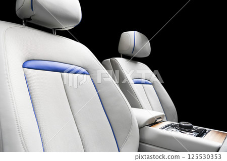 Modern luxury car white leather interior with natural wood panel. Part of leather car seat details with stitching. Interior of prestige modern car. White perforated leather. Car detailing. Car inside 125530353
