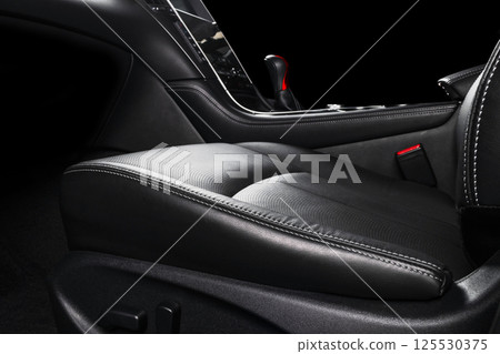 Modern Luxury car inside. Interior of prestige modern car. Comfortable leather seats. Black perforated leather cockpit with stitching. Automatic gear stick shift. Car detailing Modern Luxury car inside. Interior of prestige modern car. Comfortable leather seats. Black perforated leather cockpit with stitching. Automatic gear stick shift. Car detailing 125530375