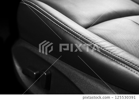 Modern Luxury car inside. Interior of prestige modern car. Comfortable leather seats. Perforated leather with stitching isolated on black background. Modern car interior. Car detailing. Car inside 125530391