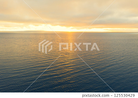Aerial view of a sunset sky background. Aerial Dramatic gold sunset sky with evening sky clouds over the sea. Sky landscape. Aerial photography. Aerial view of a sunset sky background. Aerial Dramatic gold sunset sky with evening sky clouds over the sea. Sky landscape. Aerial photography. 125530429