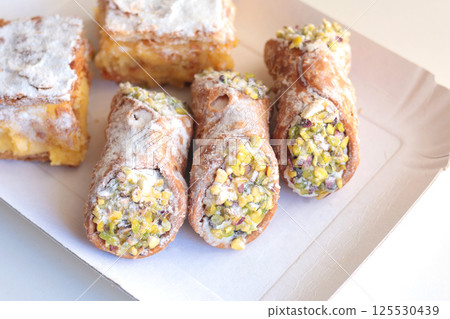 Cannoli traditional dessert of Italy. Food and sweets. Tubes of dough with filling. National cuisine.  125530439