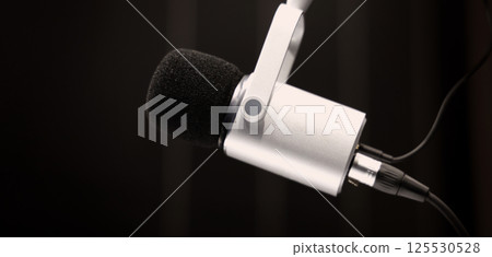 Microphone in studio. Professional studio microphone with a pop filter is suspended boom arm and studio lights. Set up mic for podcast voice over or recording high quality sound audio in a controlled. Microphone in studio. Professional studio microphone with a pop filter is suspended boom arm and studio lights. Set up mic for podcast voice over or recording high quality sound audio in a controlled. 125530528
