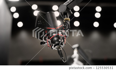 Microphone in studio. Professional studio microphone with a pop filter is suspended boom arm and studio lights. Set up mic for podcast voice over or recording high quality sound audio in a controlled. Microphone in studio. Professional studio microphone with a pop filter is suspended boom arm and studio lights. Set up mic for podcast voice over or recording high quality sound audio in a controlled. 125530531