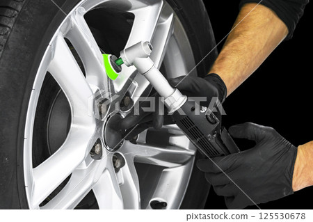 Car polish wax worker hands polishing car wheel. Buffing and polishing car disc. Car detailing. Man holds a polisher in the hand and polishes the car. Car polish wax worker hands polishing car wheel. Buffing and polishing car disc. Car detailing. Man holds a polisher in the hand and polishes the car. 125530678