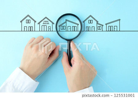 The hands of a person searching for houses and properties with a magnifying glass The hands of a person searching for houses and properties with a magnifying glass 125531001