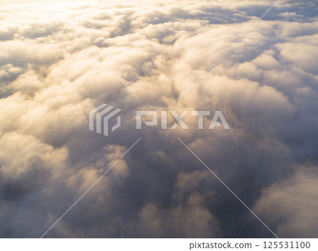 Aerial view White clouds in blue sky. Top view. View from drone. Aerial bird's eye view. Aerial top view cloudscape. Texture of clouds. View from above. Sunrise or sunset over clouds 125531100