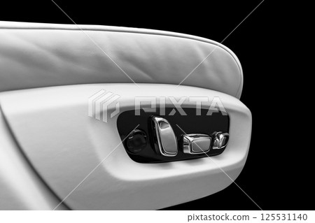 White leather interior of the luxury modern car. Perforated white leather comfortable seats with stitching isolated on black background. Modern car interior details. Car detailing. Car inside White leather interior of the luxury modern car. Perforated white leather comfortable seats with stitching isolated on black background. Modern car interior details. Car detailing. Car inside 125531140