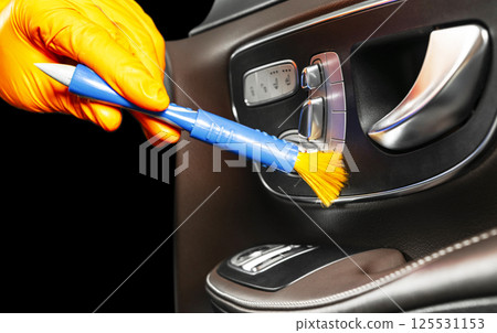 A man cleaning car with brush. Car detailing or valeting concept. Selective focus. Car detailing. Cleaning with sponge. Worker cleaning. Car wash concept solution to clean A man cleaning car with brush. Car detailing or valeting concept. Selective focus. Car detailing. Cleaning with sponge. Worker cleaning. Car wash concept solution to clean 125531153