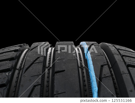 Studio shot of a set of summer car tires on black background. Tire stack background. Selective focus. Car tyre protector close up. Black rubber tire. Brand new car tires. Close up black tyre profile. Studio shot of a set of summer car tires on black background. Tire stack background. Selective focus. Car tyre protector close up. Black rubber tire. Brand new car tires. Close up black tyre profile. 125531166