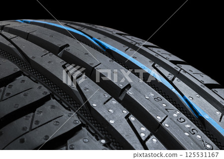 Studio shot of a set of summer car tires on black background. Tire stack background. Selective focus. Car tyre protector close up. Black rubber tire. Brand new car tires. Close up black tyre profile. Studio shot of a set of summer car tires on black background. Tire stack background. Selective focus. Car tyre protector close up. Black rubber tire. Brand new car tires. Close up black tyre profile. 125531167