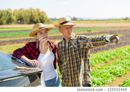 Farmers talking near car at farm field 125531448