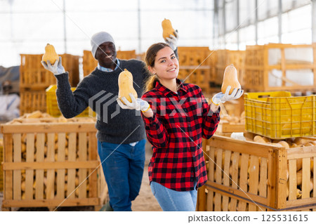 Funny farmers posing with pumpkins 125531615
