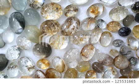 Macro mineral quartz hairy stone, quartz with rutile on a white background close up Macro mineral quartz hairy stone, quartz with rutile on a white background close up 125531665