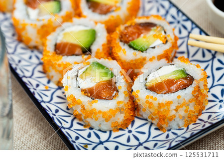 Plate is filled with California rolls with masago. 125531711