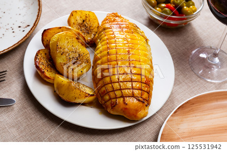 Chicken fillet baked with bacon filling, garnished with fried potato slices. 125531942