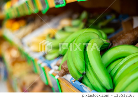 Fresh green bananas platano macho on counter in supermarket 125532163