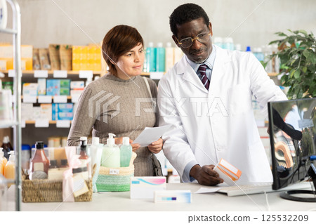 Male pharmacist offers woman prescription pills 125532209
