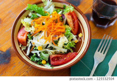 Plate contains portion of salad from fresh China cabbage, carrot, corn Plate contains portion of salad from fresh China cabbage, carrot, corn 125532504