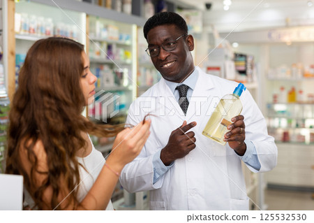 Pharmacist giving woman guidance about haircare Pharmacist giving woman guidance about haircare 125532530