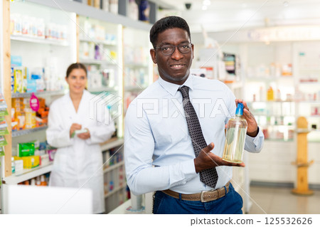 Man holding bottle with haircare product Man holding bottle with haircare product 125532626