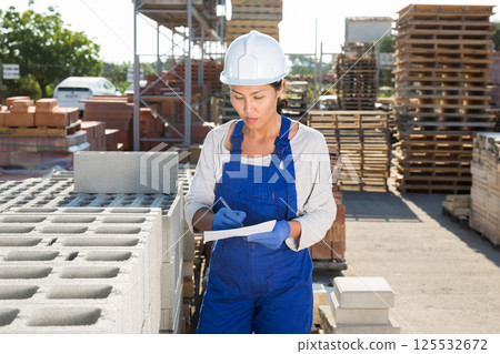 Female taskmaster in outdoor warehouse Female taskmaster in outdoor warehouse 125532672