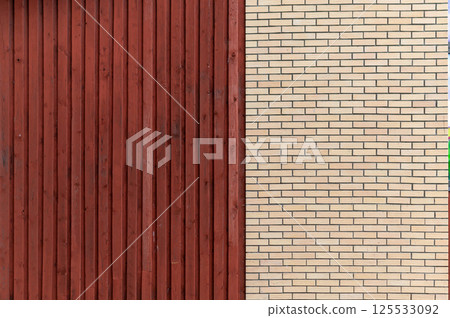 Modern architectural contrast of red wooden and beige brick walls at an urban location 125533092
