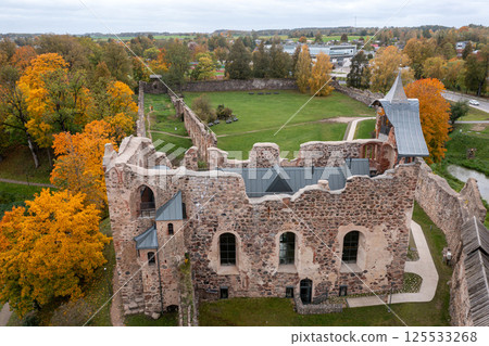 Ruins of a historical castle surrounded by colorful autumn trees in a serene landscape Ruins of a historical castle surrounded by colorful autumn trees in a serene landscape 125533268
