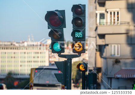 Traffic signals indicating bus lane and pedestrian crossing in an urban area during daylight Traffic signals indicating bus lane and pedestrian crossing in an urban area during daylight 125533350