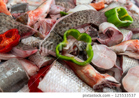 Fresh fish and vegetables prepared for cooking at a bustling market in the city 125533537