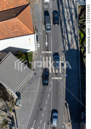 Aerial view of urban intersection with cars and pedestrians near a waterfront area 125533685