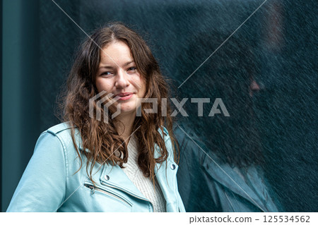 portrait of a young sensual brunette with long hair by a polished dark marble wall portrait of a young sensual brunette with long hair by a polished dark marble wall 125534562
