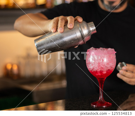 Bartender prepares preparing refreshing tequila sunrise drink - cocktail tequila sunrise with tequila, juice and grenadine syru Bartender prepares preparing refreshing tequila sunrise drink - cocktail tequila sunrise with tequila, juice and grenadine syru 125534813